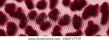 Top view of red transparent fabric mesh with leopard print background. Leopard wrinkled smooth cloth in burgundy tones backdrop
