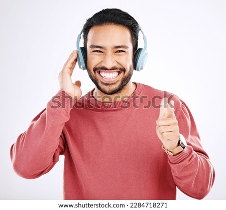 Headphones, smile and music, excited man in studio isolated on white background streaming radio and happiness. Podcast subscription, technology and song, Indian guy listening to audio online to relax