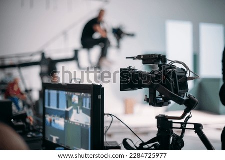 A professional film and video camera on the set. Filming day, equipment and crew. Technique of modern video filming. Royalty-Free Stock Photo #2284725977