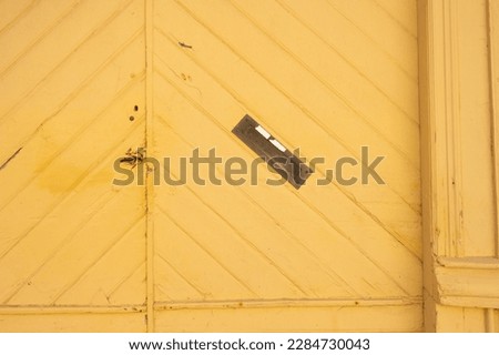 Angled letter box on a yellow port door.