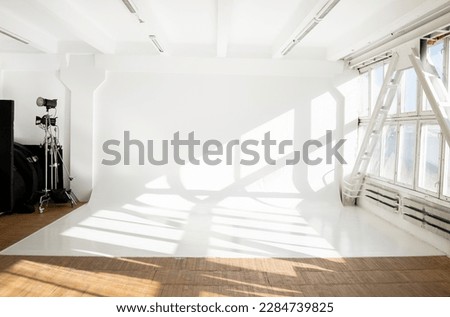 Large sunny photo studio with cyclorama and large panoramic windows.