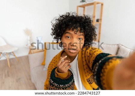 Happy african american teen girl blogger smiling face talking to webcam recording vlog. Social media influencer woman streaming making video call at home. Headshot portrait selfie webcamera view Royalty-Free Stock Photo #2284743127
