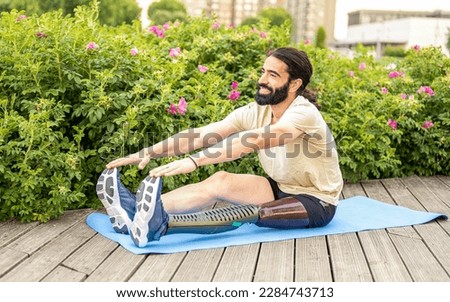 Young man of Hispanic origins with a disability practicing stretching at city park, concept of motivation and determination and social inclusion