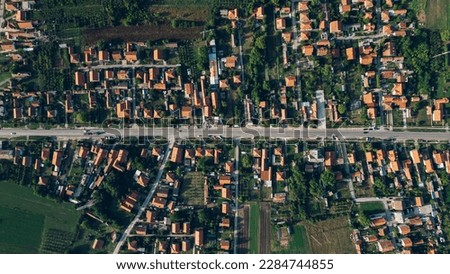 A vibrant aerial view of a residential area, featuring buildings and lush plants amidst the bustling crowd below.