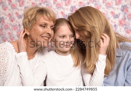A teenage girl hugs her grandmother and mother, expresses her love to them.