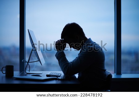 Tired or stressed businessman sitting in front of computer in office Royalty-Free Stock Photo #228478192