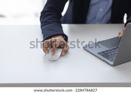 Image of Asian man hands clicking computer mouse
