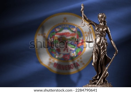 Minnesota US state flag with statue of lady justice and judicial scales in dark room. Concept of judgement and punishment, background for jury topics Royalty-Free Stock Photo #2284790641