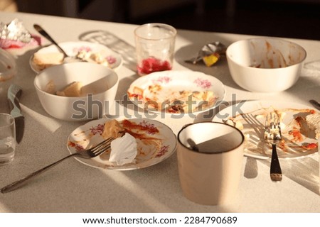 Empty dirty plates with spoons and forks on the table after meal. Banquet ending concept. Unwashed dishes ready to cleaning