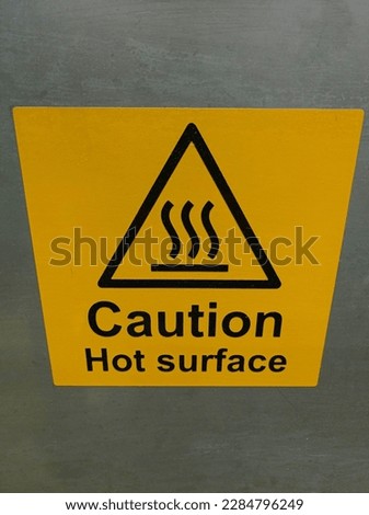 hot surface caution signs stickers affixed to machines in industry