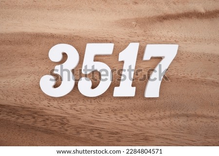 White number 3517 on a brown and light brown wooden background.