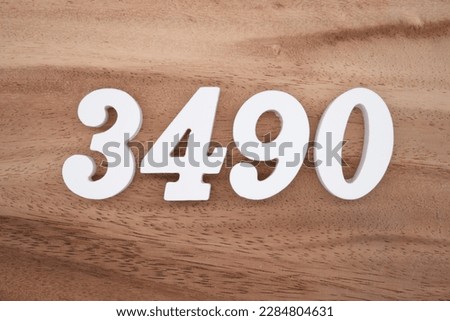 White number 3490 on a brown and light brown wooden background.