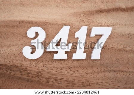 White number 3417 on a brown and light brown wooden background.
