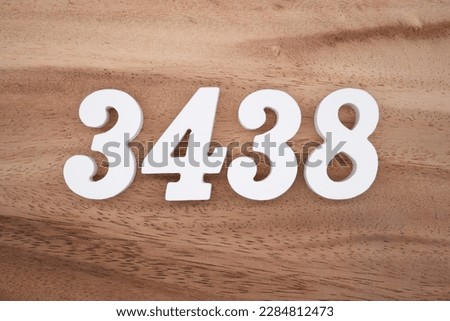 White number 3438 on a brown and light brown wooden background.