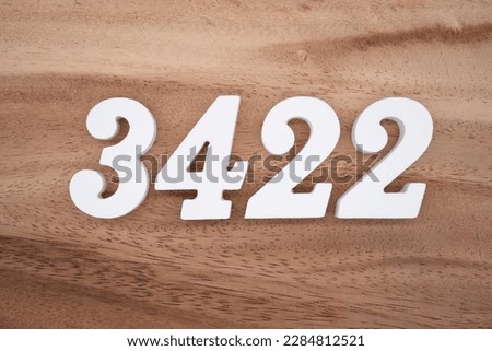 White number 3422 on a brown and light brown wooden background.