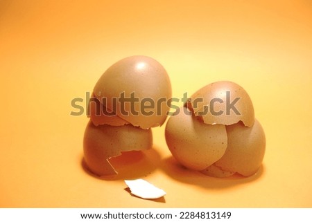 Closeup picture of broken egg shell isolated in orange background, easter design , design for card or invitation.