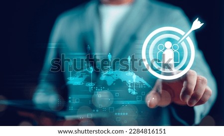 Businessman touching virtual human icon on dartboard with arrow for Global business CRM or Customer Relation Management and customer focus target group concept, social media. Digital marketing online.