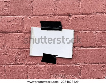 Terracotta colour painted urban brick wall with a white empty sticky tape  note glued flyer  