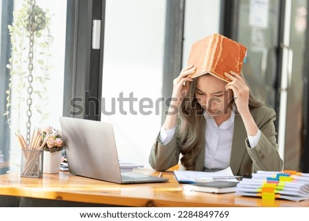 Businesswoman looking annoyed and stressed, sitting at the desk, using a laptop, thinking, feeling tired and bored with depression problems