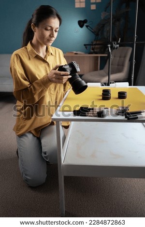 Professional female photographer shooting beauty products on the table in her home studio. Photography and makeup blogging. Copy space