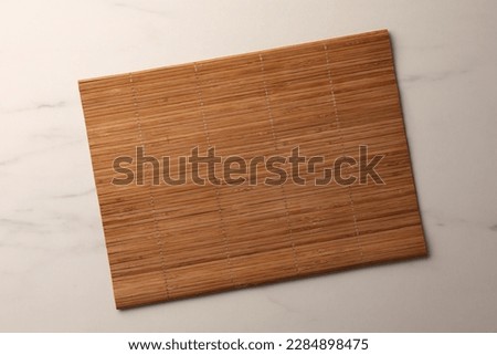 Bamboo mat on white marble table, top view. Space for text Royalty-Free Stock Photo #2284898475