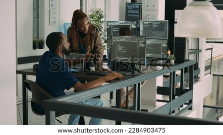 African american team of developers talking about source code running on screen, analyzing server information. Database admins collaborating on data coding project in ai programming room. Royalty-Free Stock Photo #2284903475
