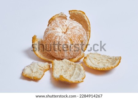 Peeled Orange with outer layer of skin removed, leaving the juicy and colorful flesh inside exposed on isolated white background Royalty-Free Stock Photo #2284914267