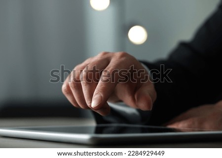 Closeup view of man using new tablet at desk indoors