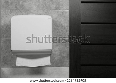 New paper towel dispenser hanging on wall in bathroom Royalty-Free Stock Photo #2284932905