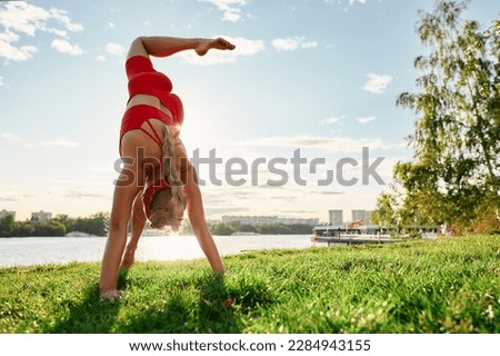 Young woman doing innovative animal flow movement outdoors, training animal flow at sunset Royalty-Free Stock Photo #2284943155