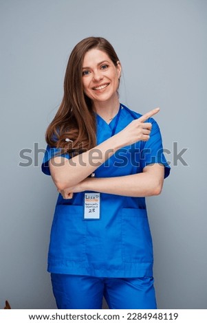 Smiling doctor woman or nurse pointing finger up.