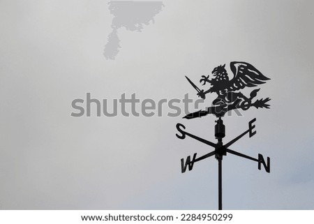 Black dragon wind vane against the sky. Weather vane reflecting compass points Royalty-Free Stock Photo #2284950299