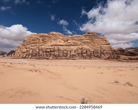 Wadi Rum World Heritage Nature Reserve in Jordan : Spectacular scenery mixing sand and dramatic rock formations under intense cloudy blue sky