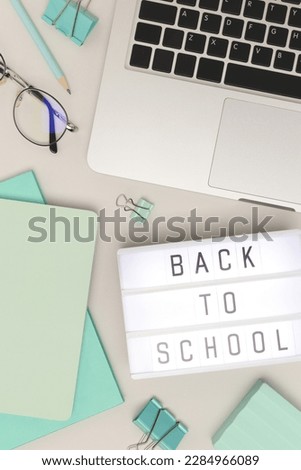 Back to school. Workspace with lightbox, laptop and office supplies on a gray background. Online studying concept.