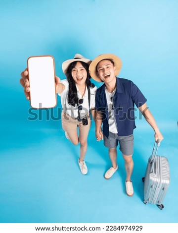 Asian couple traveling image  isolated on blue background