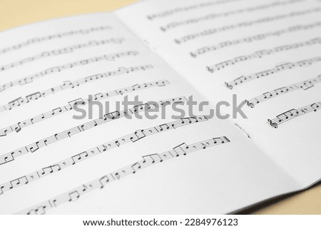 Sheet music book on beige table, closeup