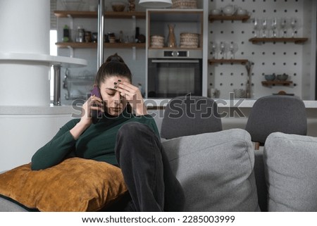 Sad millennial woman has difficult phone talk hold gadget by ear listen to unexpected bad news think on answer. Compassionate young lady support friend by cell try to help ponder on advice. Royalty-Free Stock Photo #2285003999