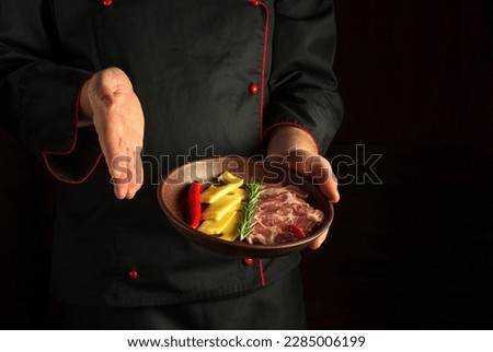 Professional chef presents an appetizer on a serving plate with sliced ham and cheese. Black free space for recipe or menu