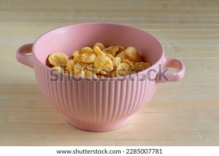 Corn flakes in pink soup bowl. Breakfast Cereal Royalty-Free Stock Photo #2285007781