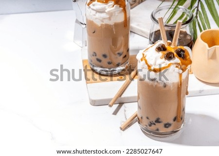 Tapioca boba balls coffee frappe, asian trendy cold coffee drink with tapioca balls and whipped coconut cream and caramel sauce Royalty-Free Stock Photo #2285027647