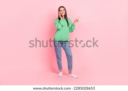 Full length photo of positive glad lady user wear trendy clothes speaking device looking empty space isolated on pink color background