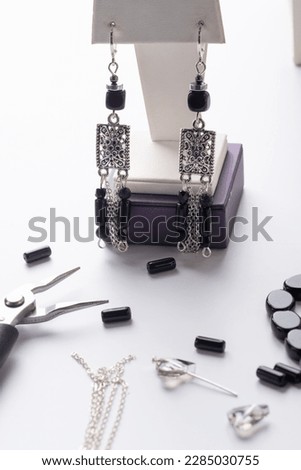 author ethno errings demonstrated  with tool and details against  white background. fashion and jewelry concept