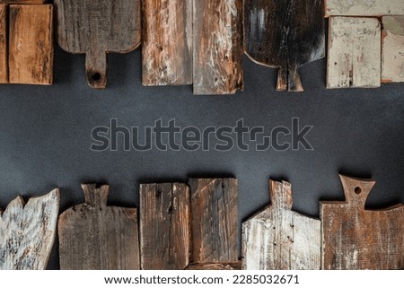 Set of wooden chopping cutting boards on a dark background. Handmade Charcuterie style serving boards. Manual work. place for text, top view. Royalty-Free Stock Photo #2285032671