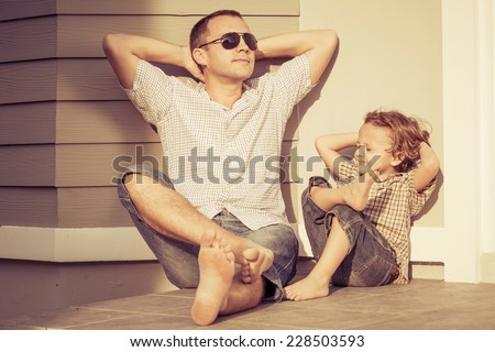 Dad and son playing near a house at the day time Royalty-Free Stock Photo #228503593