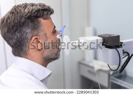 Man testing breathing function by spirometry. Diagnosis of respiratory function in pulmonary disease Royalty-Free Stock Photo #2285041303