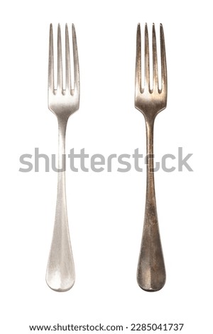 Polished and tarnished sterling silver fork handles, old and often used. Hydrogen sulfide and oxygen in the air react with the outermost layer of the metal and gives a thin, dark layer of corrosion. Royalty-Free Stock Photo #2285041737