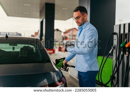A man fills his car with fuel before going to work at a self-service gas station Royalty-Free Stock Photo #2285055005