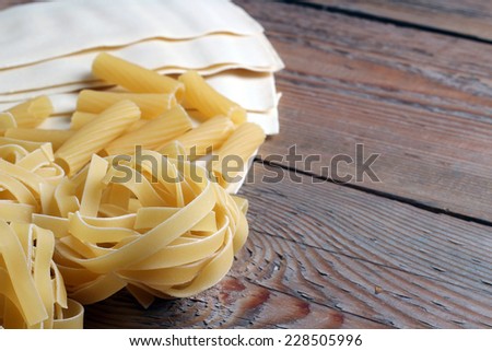 Picture of a lot of raw pasta on a wooden background
