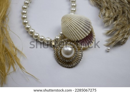 Mussel and pearl necklace.  Clam and pearl necklace placed on a white background.  surface, reeds