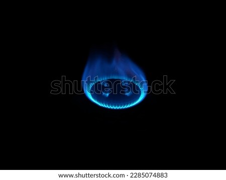 a gas stove with a blue flame at night without lights